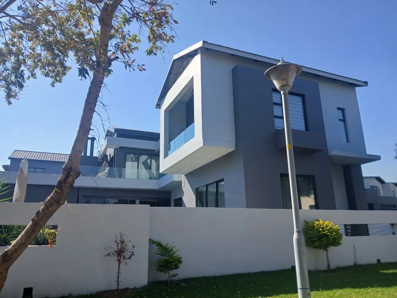 House exterior before and after comparison showing a change from a worn wall to a painted finish - after