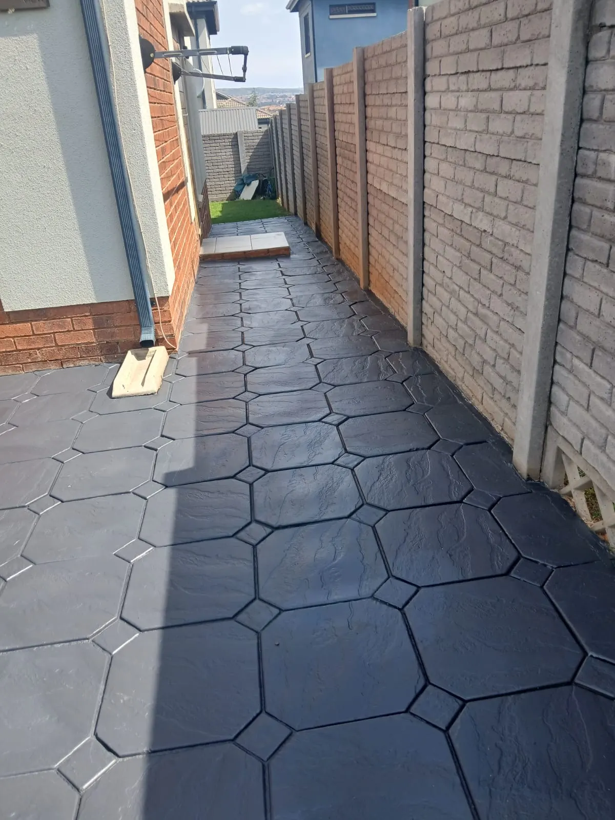 Paving area before and after comparison showing a darker finished surface - after