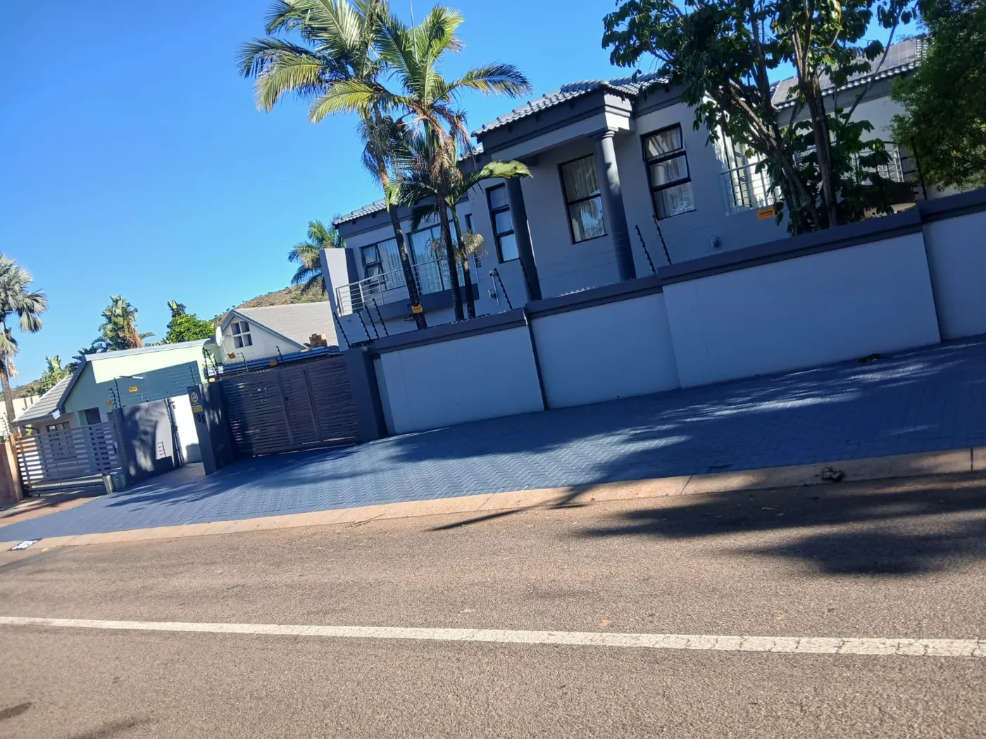 Home with a freshly painted boundary wall and blue paving