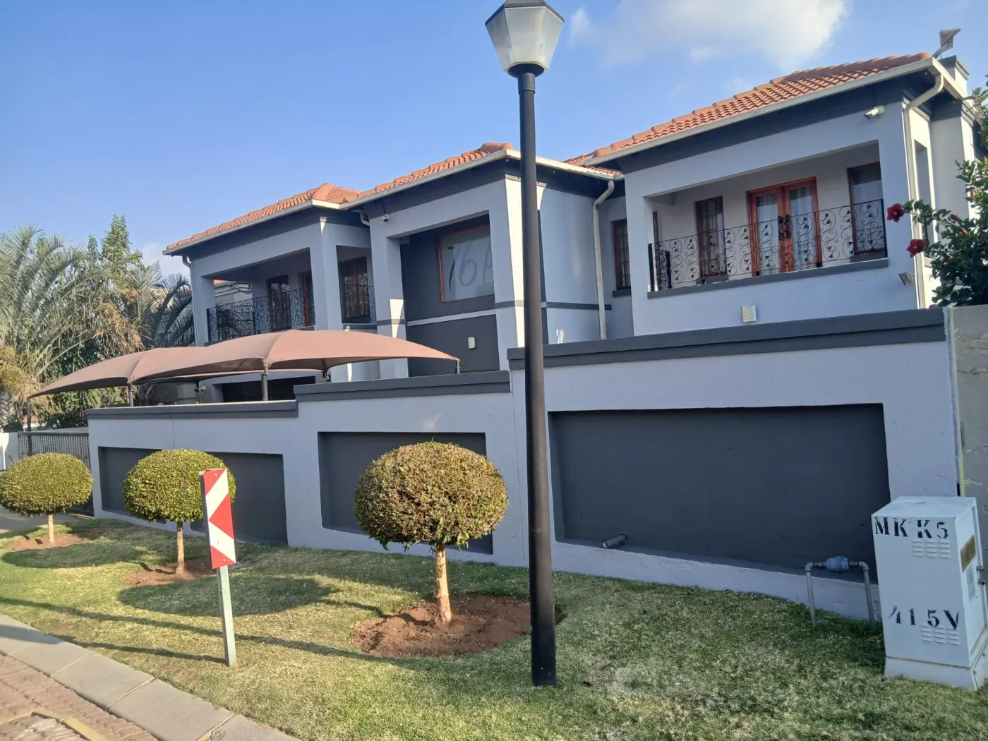 Double-storey home painted grey with charcoal garage and boundary wall