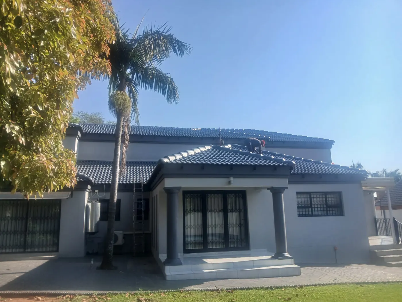 Grey house with dark tiled roof and white trim
