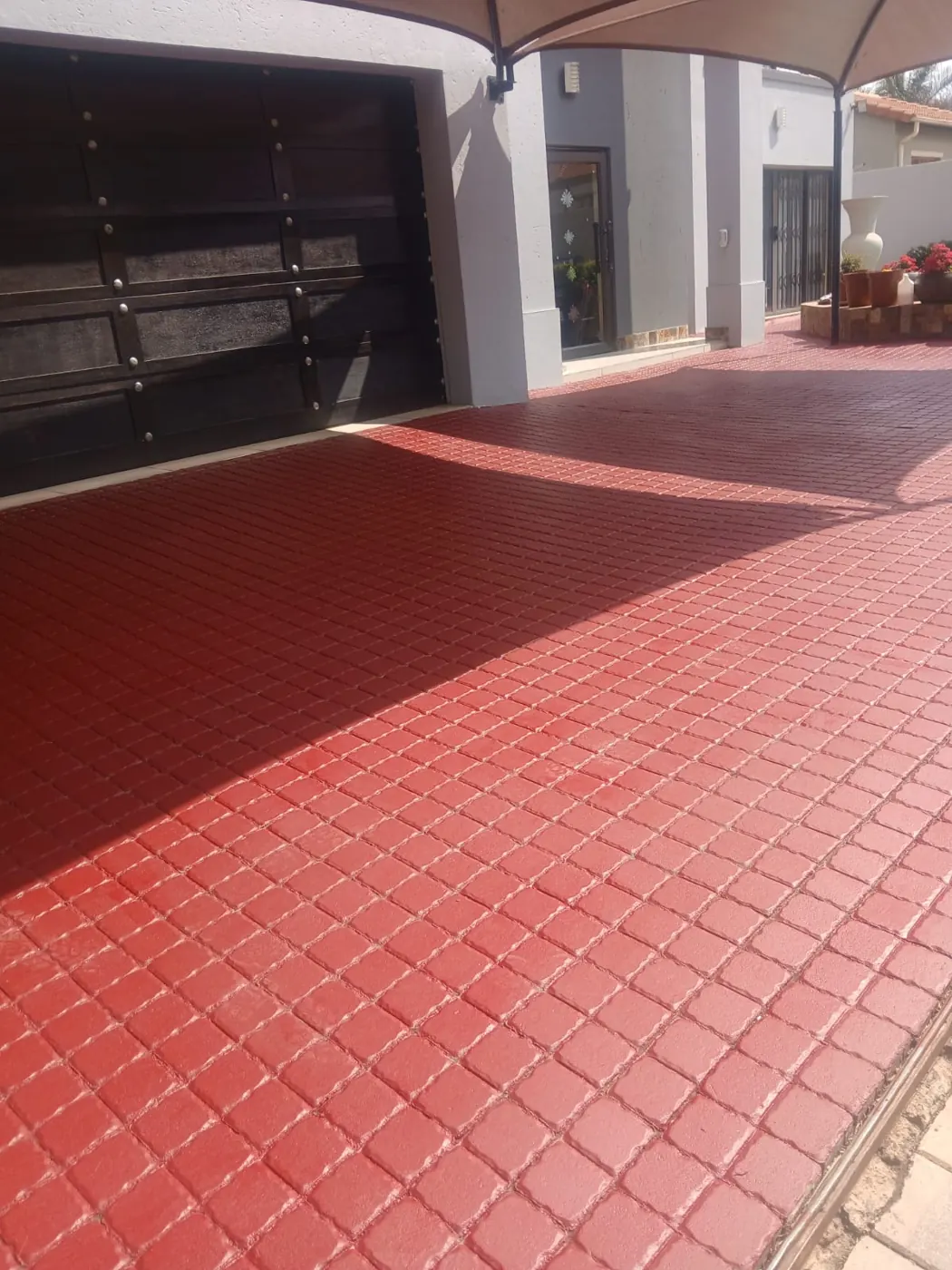 Red square-tile paving in front of a garage